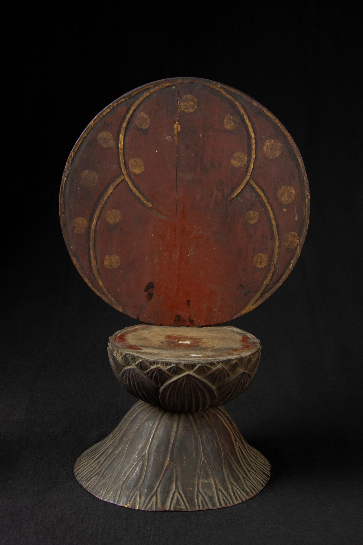 Carved wood folk bodhisattva seated in royal ease before a red and gold aureole on a lotus base, view 5 of 5