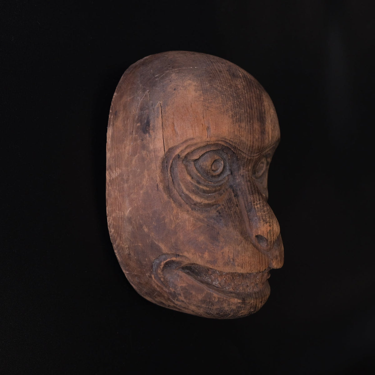 Hand-carved wooden monkey face mask mold with ringed eyes and a broad grin, view 4 of 8