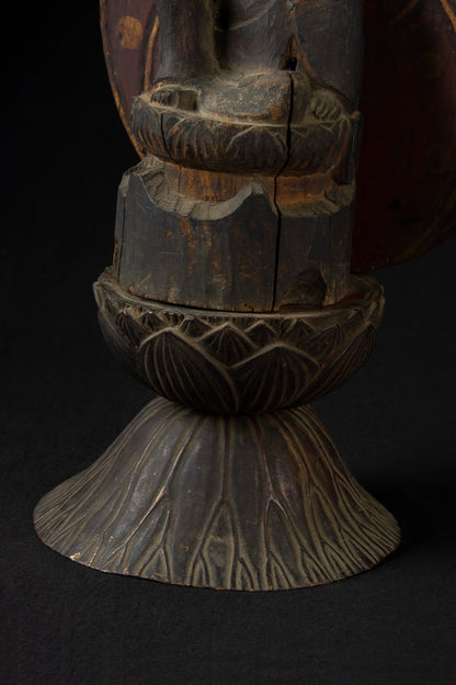 Carved wood folk bodhisattva seated in royal ease before a red and gold aureole on a lotus base, view 4 of 5