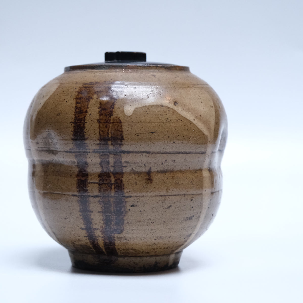 Edo period stoneware mizusashi (tea ceremony water jar) with trailing off-white and brown glazes and black lacquer lid, view 1 of 12