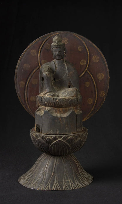 Carved wood folk bodhisattva seated in royal ease before a red and gold aureole on a lotus base, view 2 of 5