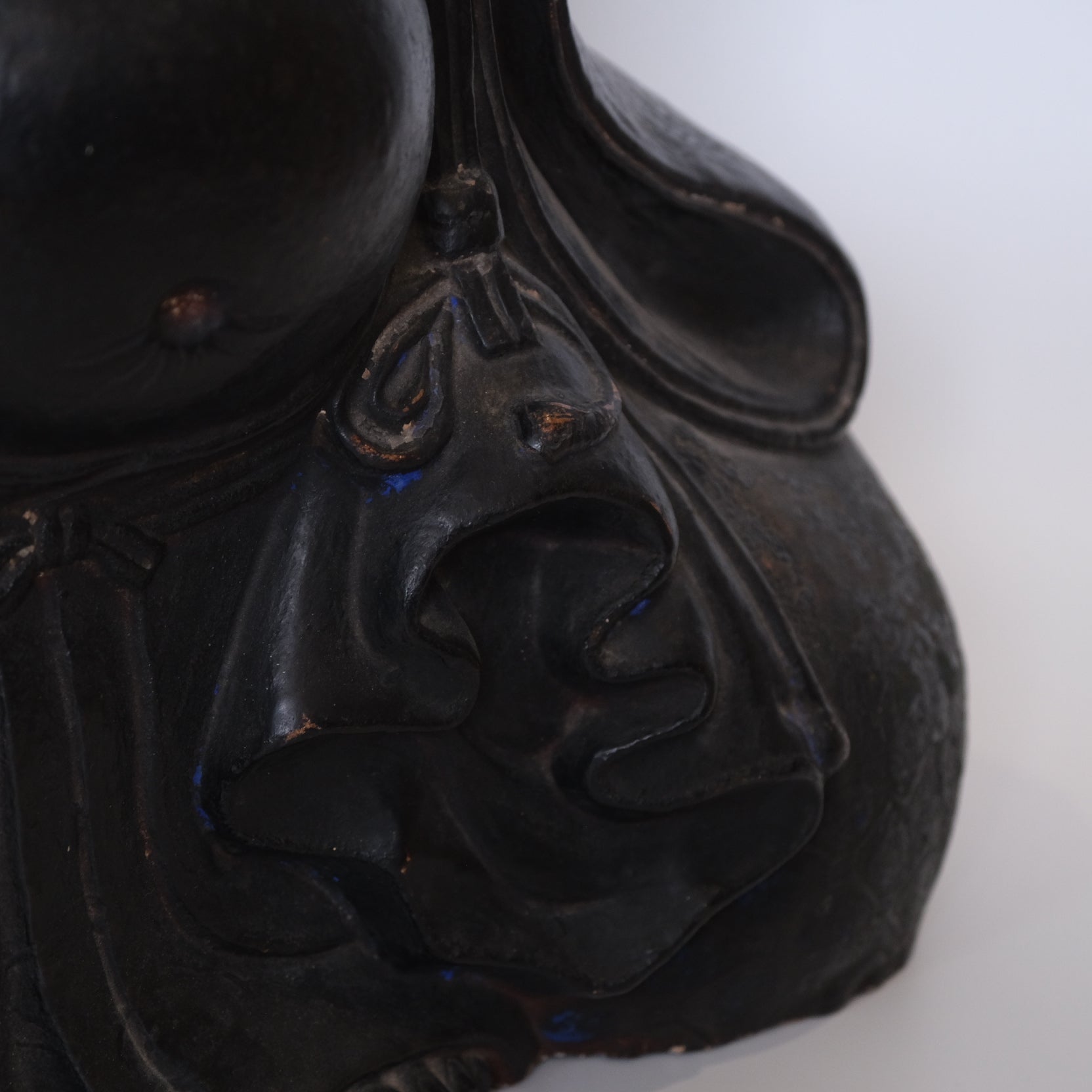 Detail of Hotei's robe and seated posture on late 18th century ceramic figure