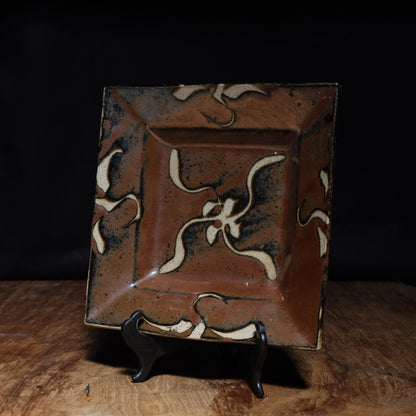 Shoji Hamada square stoneware dish with kaki glaze and wax-resist floral design, view 1 of 12