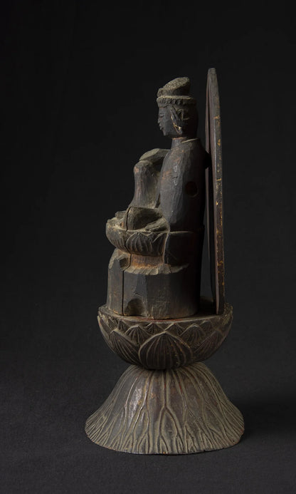 Carved wood folk bodhisattva seated in royal ease before a red and gold aureole on a lotus base, view 3 of 5
