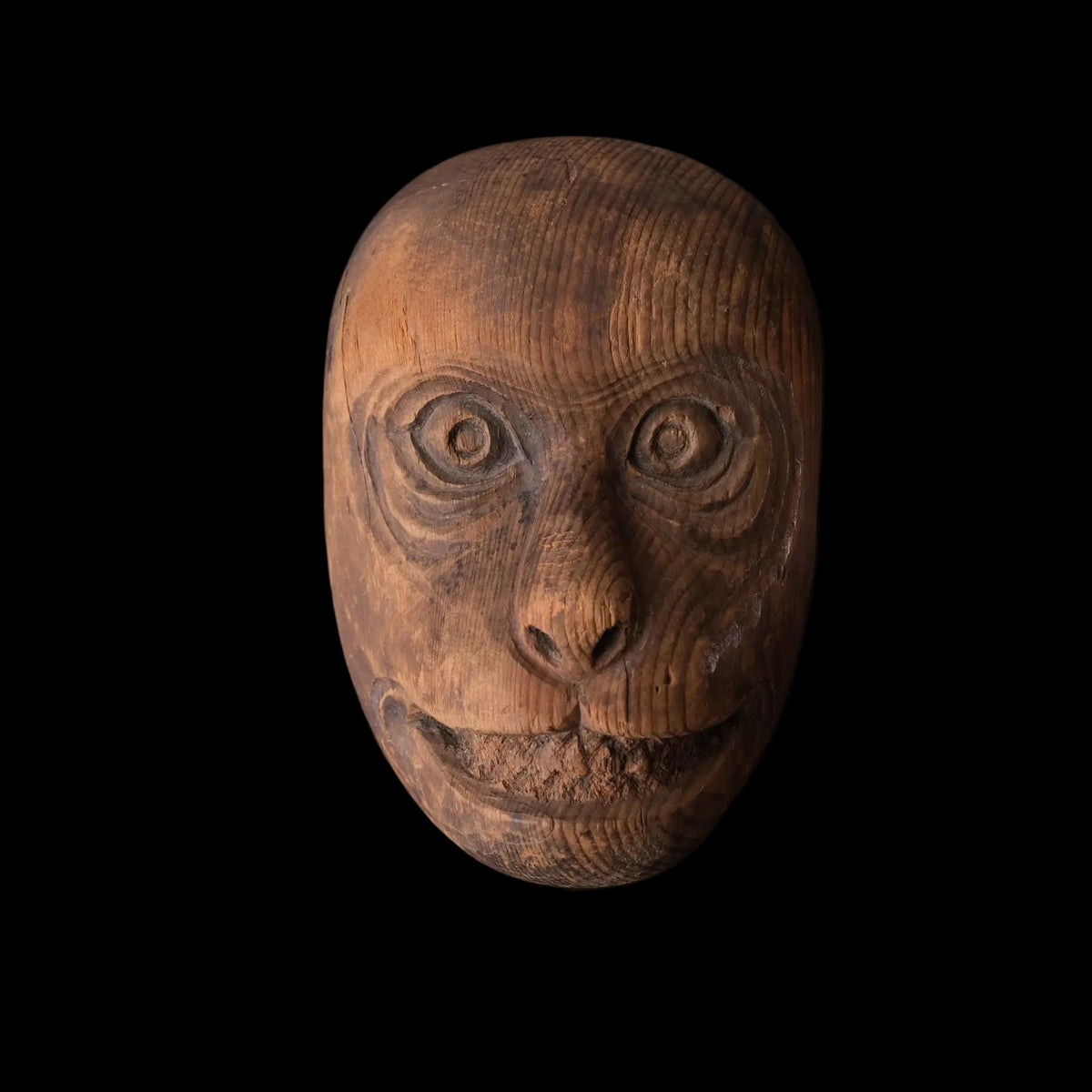 Hand-carved wooden monkey face mask mold with ringed eyes and a broad grin, view 1 of 8
