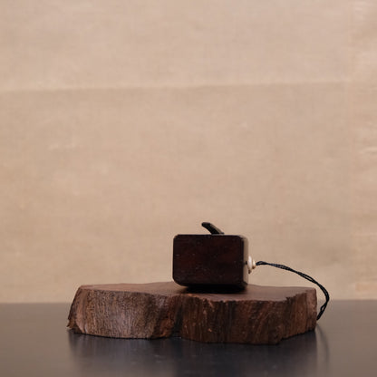 Three-quarter view of Japanese wooden gunpowder flask with bone fitting