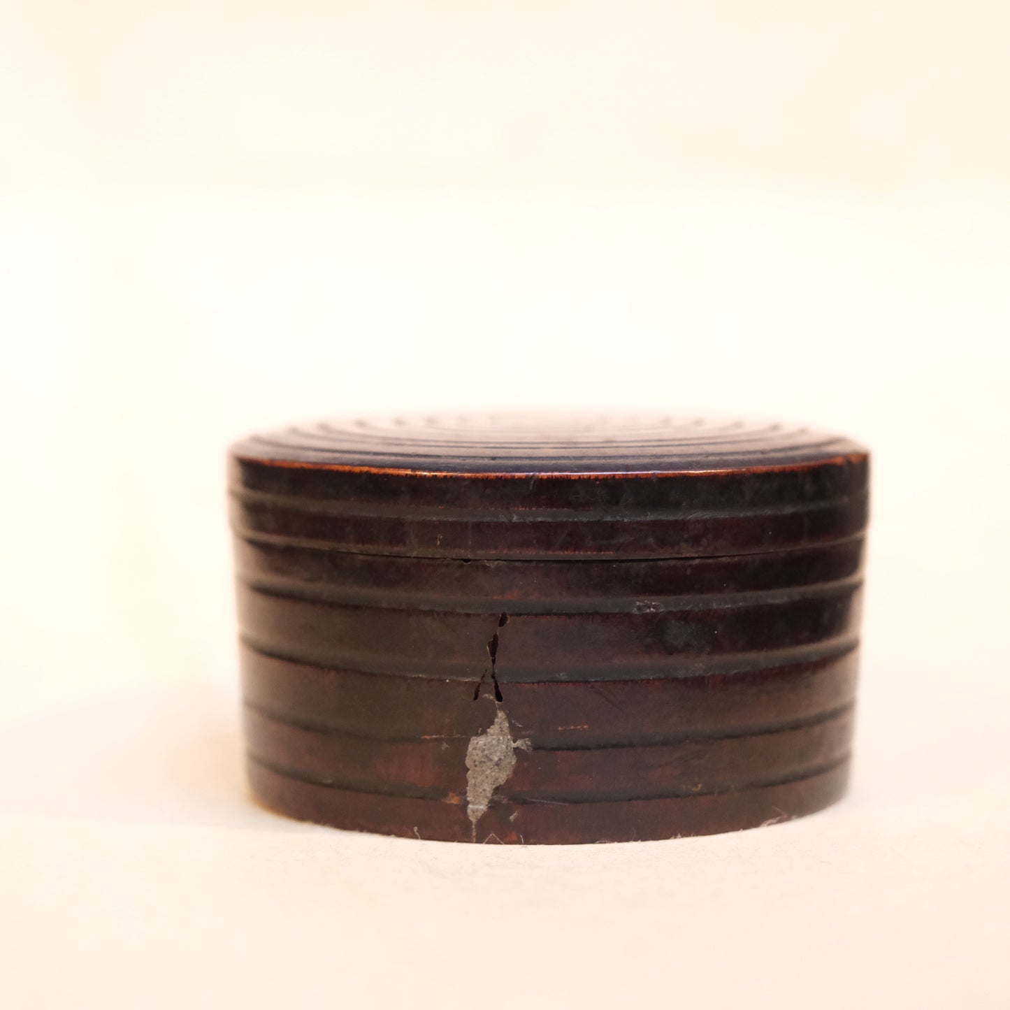 Detail of repair on Edo period Japanese wooden perfume container, 2-inch diameter