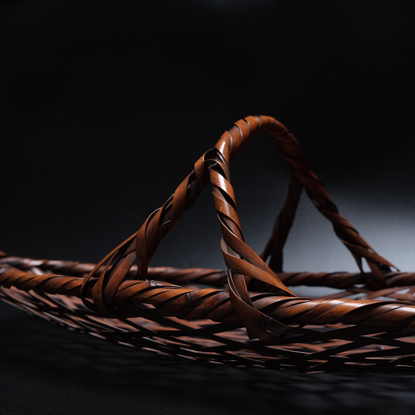 Side view of signed elliptical bamboo basket, 32x12.5x8.75 inches